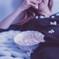 Woman watching movie and eating popcorn
