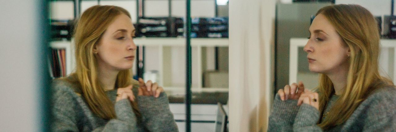 Interning at a Psychiatric Hospital With a Mental Illness photo of woman in front of mirror with eyes closed