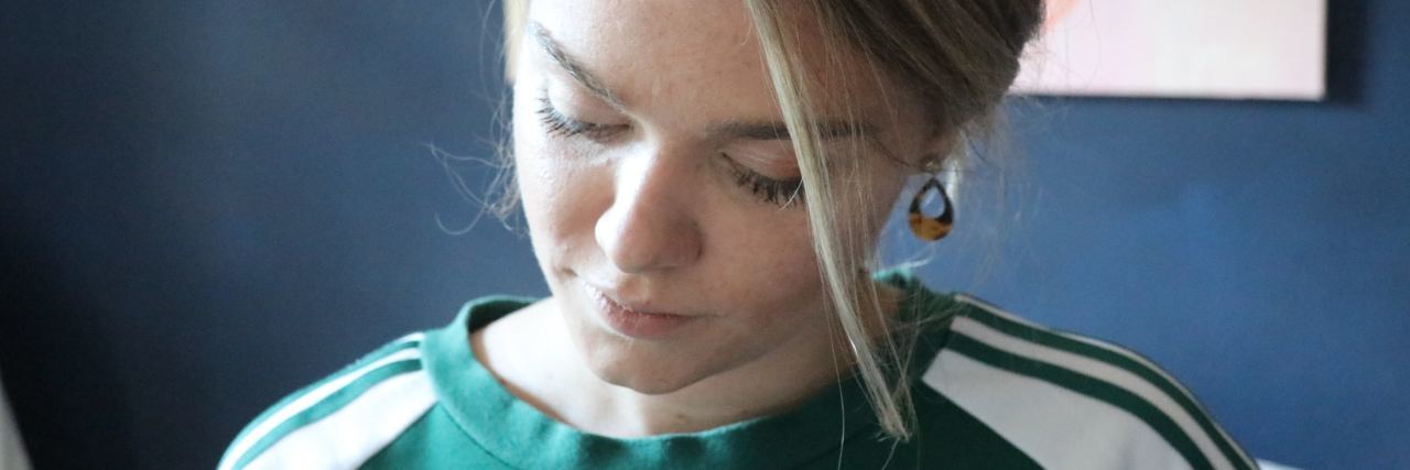 Things Doctors Say to Me and Other Fibromyalgia Patients photo of young woman close up and looking down, a strand of hair across her face