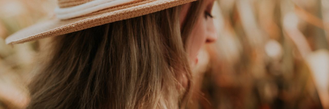 What the Church Doesn't Say About Depression and Suicide photo of woman with blonde hair, wearing hat in field with golden light