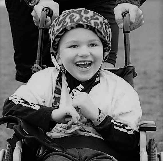 the author's son, Sam, smiling in his wheelchair