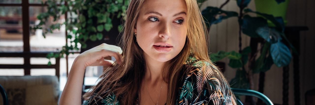 photo of woman in restaurant looking back over shoulder with elbow resting on table