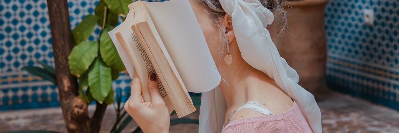 Bipolar Disorder and Anxiety Make Me Feel Invisible photo of woman covering face with book