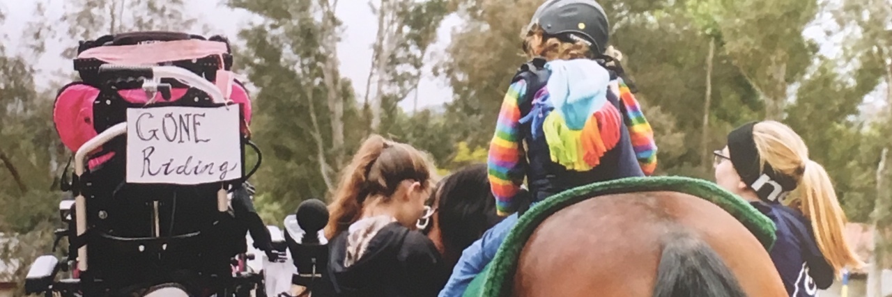 The Benefits of Horseback Riding for Kids With Cerebral Palsy Megan's daughter on a horse. Her wheelchair sits nearby with a sign on it -- "Gone Riding."