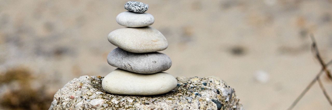 4 Therapists Who Helped With My Mental Illness A stack of rocks sits serenely in front of the camera.