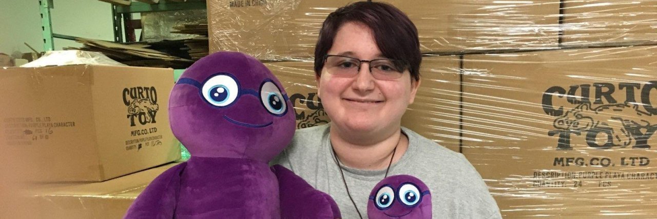 The Purple Playas Foundation's Parker Lentini holding two Purple Puff stuffed characters