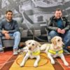 Dr. Amit Patel and Jonathan Attenborough with their service dogs on the floor in front of them