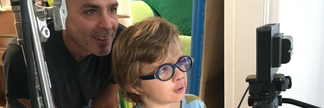 Inspiration Behind Disorder: The Rare Disease Film Festival The filmmaker with their son, near the video camera