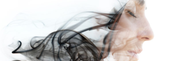 Double exposure photograph of a young woman combined with an image of the smoke