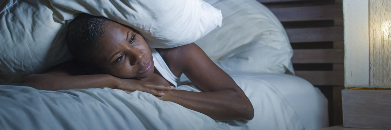 When Chronic Pain Causes 'Painsomnia' and Anger Issues image of a stressed woman lying in bed, between pillows