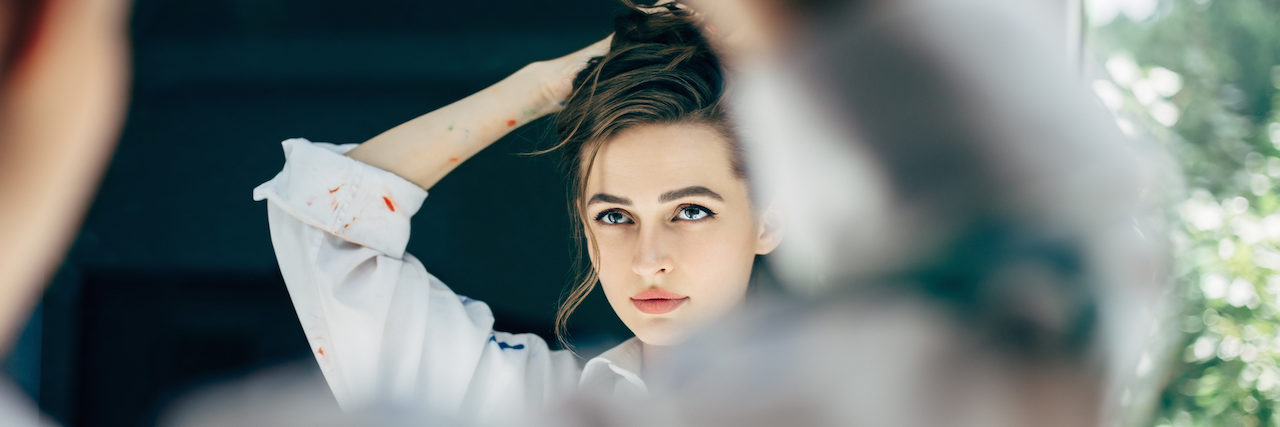 What It Means to Be a 'Functioning' Borderline young woman looking herself reflection in mirror