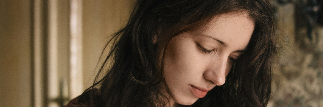 Doctors Need to Acknowledge Patient Concerns A woman looks down at the ground in a somber mood.