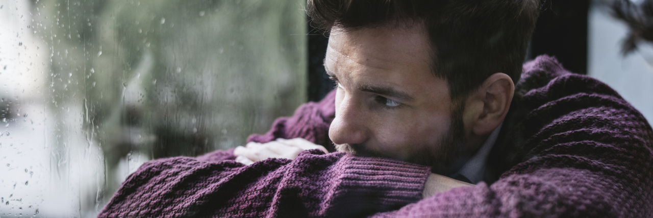 Why It’s OK to Have a Pity Party A man sits with his head down looking outside a rainy window.