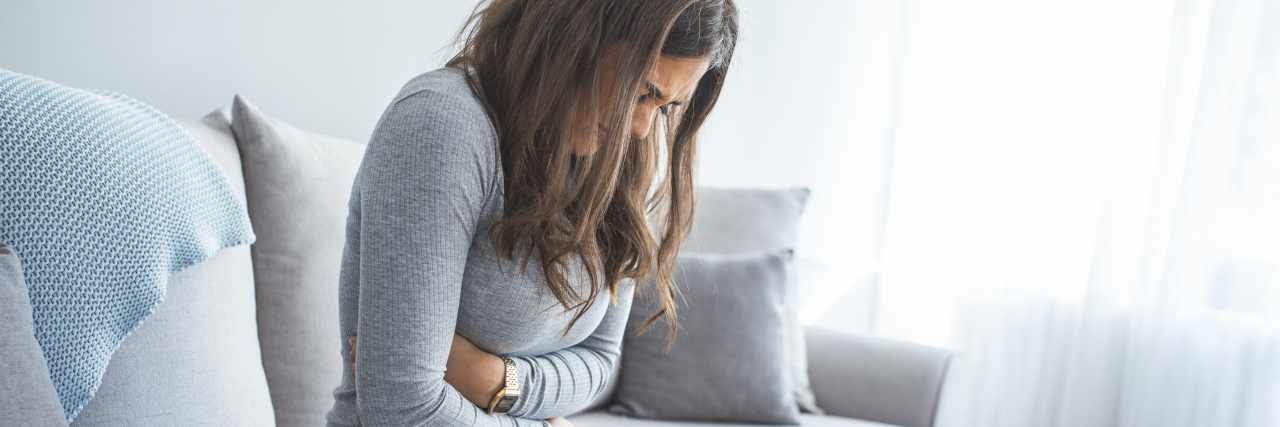 How Listening to My Gut and a New Symptom Saved My Life a woman experiencing stomach pain