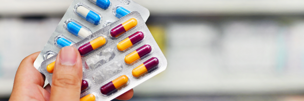 The Reality of Taking Medication With Chronic Illness Hand holding medicine capsule pack