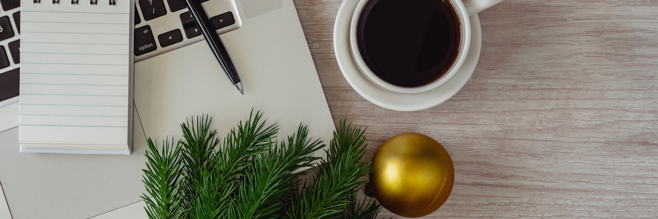 Seasonal Remote Jobs for People With Disabilities or Chronic Illnesses Laptop and notepad with ornaments balls on wood table.