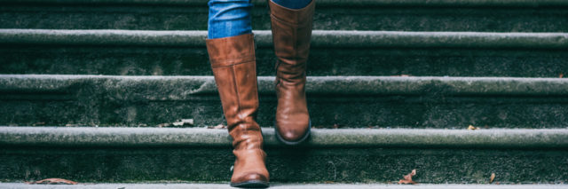 woman walking down the stairs wearing boots