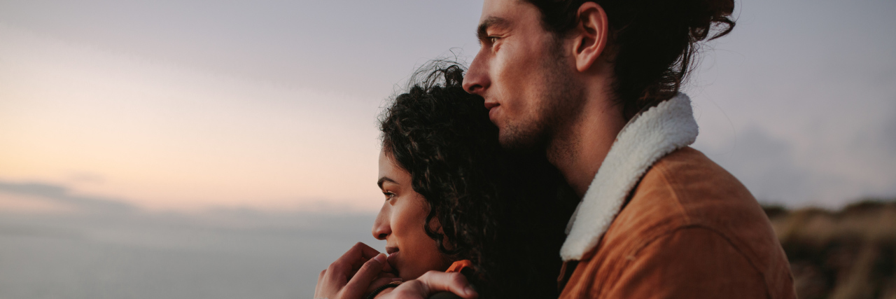 Falling In Love With Someone With Chronic Illness Isn't For Everyone A couple stands together in a warm embrace.