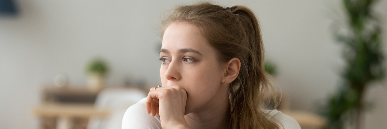 How Chronic Pain Ages You Seriouswoman sitting on couch alone at home