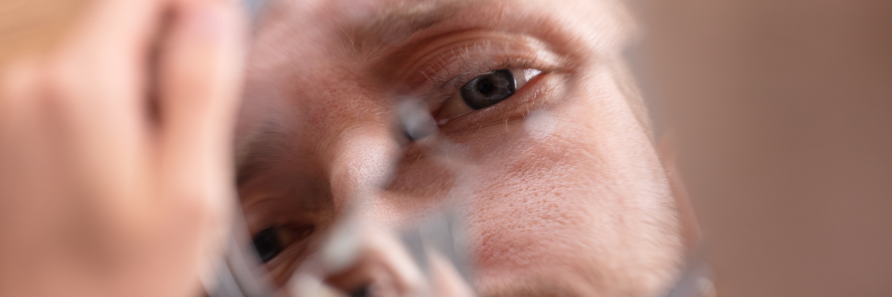 Overcoming Self-Criticism as the Parent of a Child With Medical Needs Man's face in broken mirror.