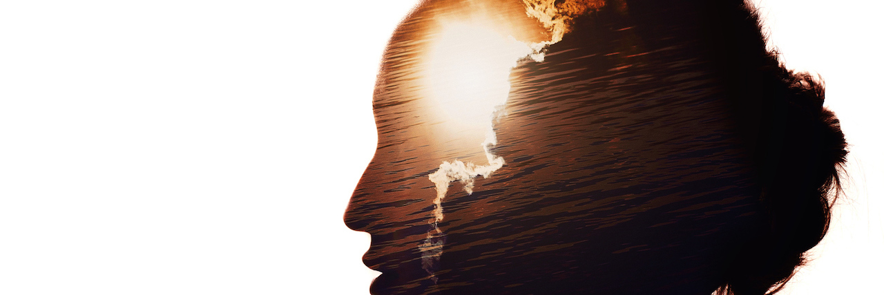 Silhouette of a woman's profile with sun behind the clouds
