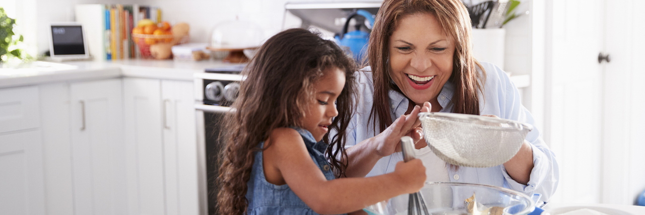 Love and Connection in Anorexia Recovery with Abuelita's Tortillas Young Latina girl making cake in the kitchen with her grandma,