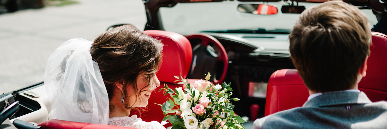 Bride and groom in a car after the wedding
