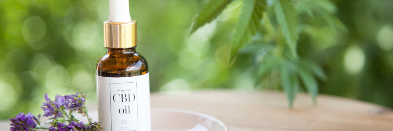 Is It Legal to Give CBD to Children? CBD Cannabis Oil (cannabidiol) bottle and dropper on small plate.
