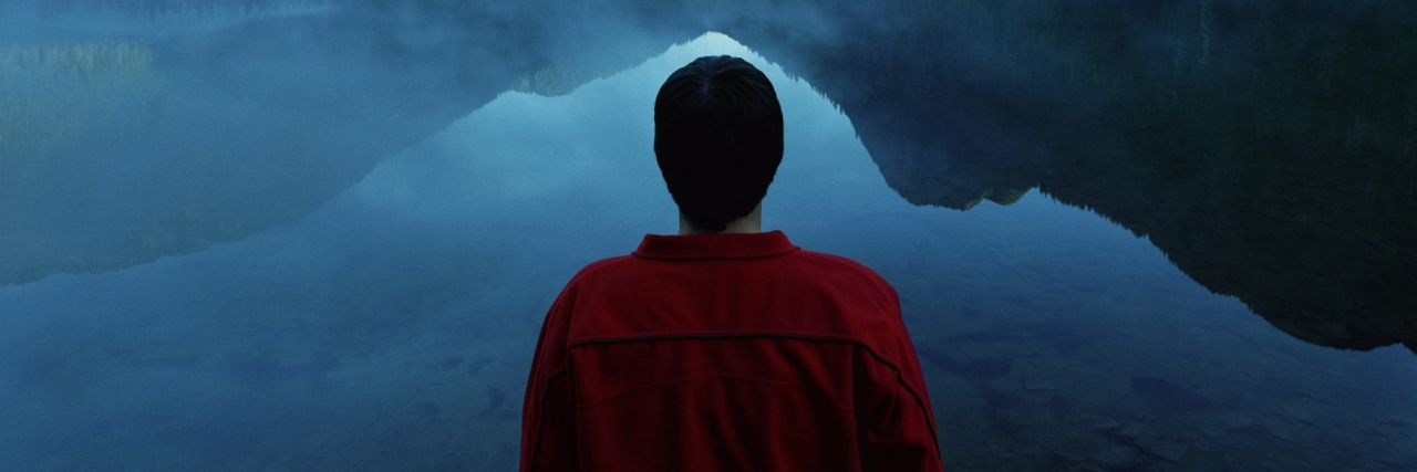 Why OCD Is Like Riding the Wave A man stands looking out over the water.