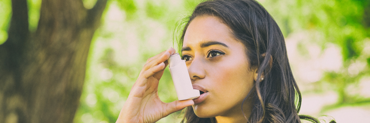 Why Blaming People With Asthma for Their Carbon Footprint Causes Harm Woman with asthma using inhaler.