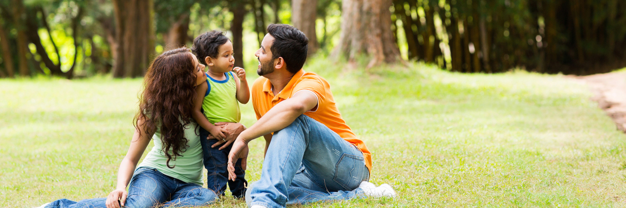 What I Wish People Knew About Parenting a Child With a Disability Young family sitting outdoors.