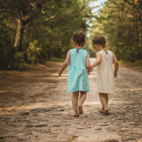 Young sisters walking down a forest road