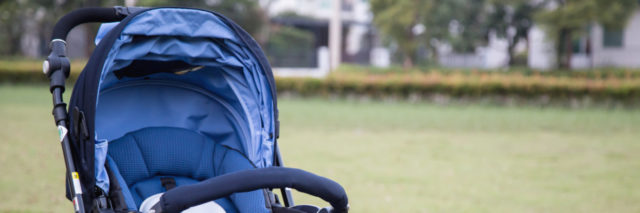 an empty baby stroller in a grass field