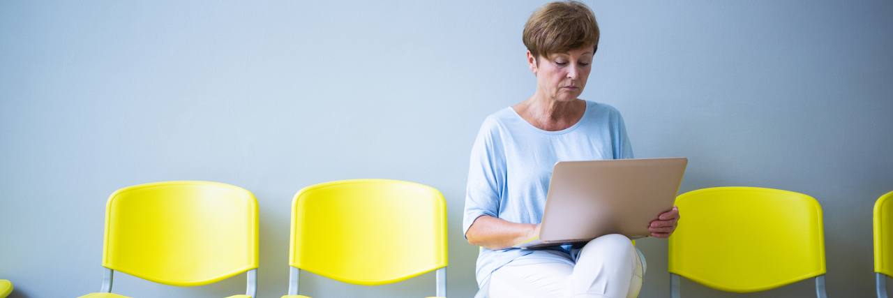 Tips for Managing Multiple Chronic Illnesses Patient sitting with laptop in waiting room.