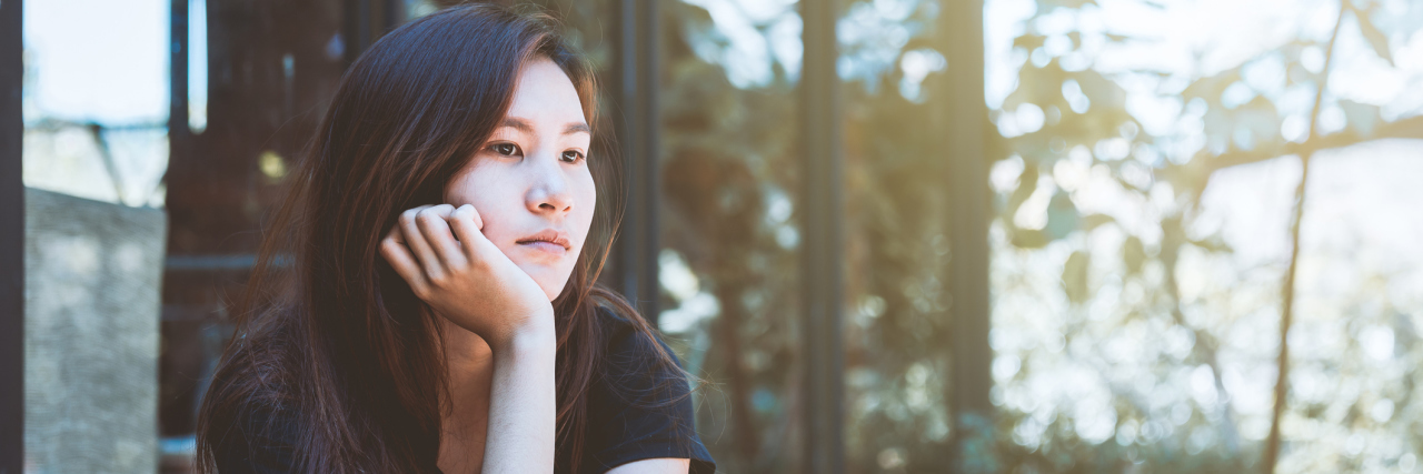 How Cerebral Palsy Impacts My Eating Disorder A woman sits staring off to the side.
