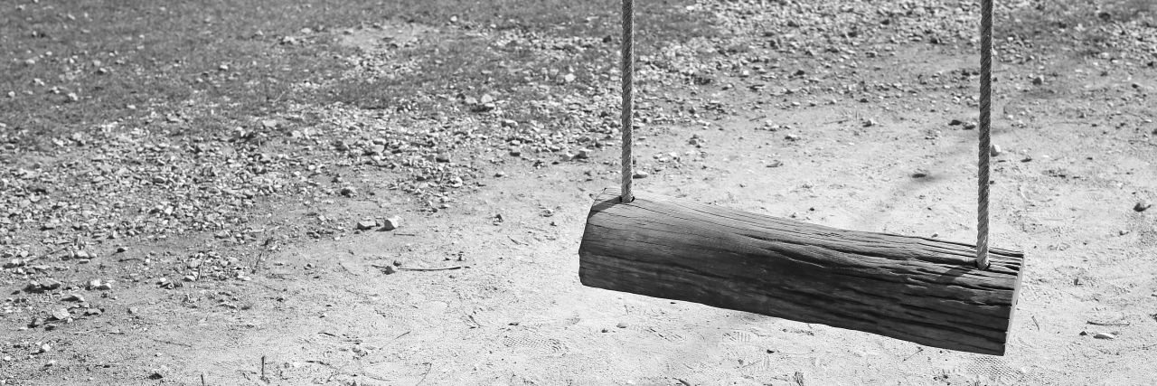 Empty swing with shadows in black and white.