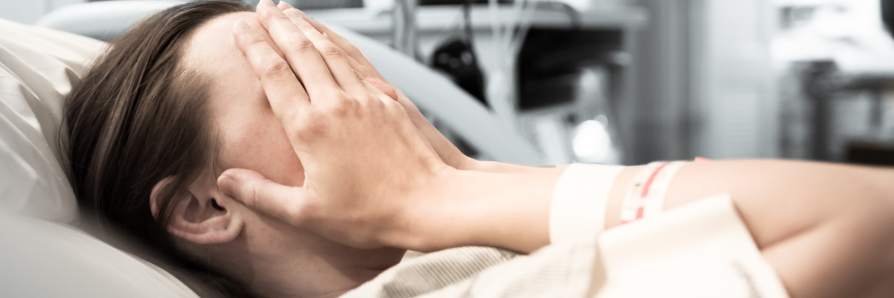 ER Tech Saying You Don't Deserve to Be in the ER A woman lays in bed with her hands over her face.