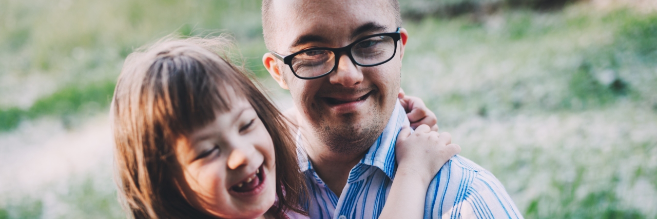 Down Syndrome Isn’t Something Terrible Picture of girl and man with Down syndrome hugging