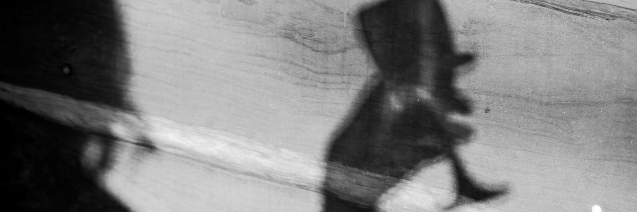 a shadow of a woman holding a wine glass