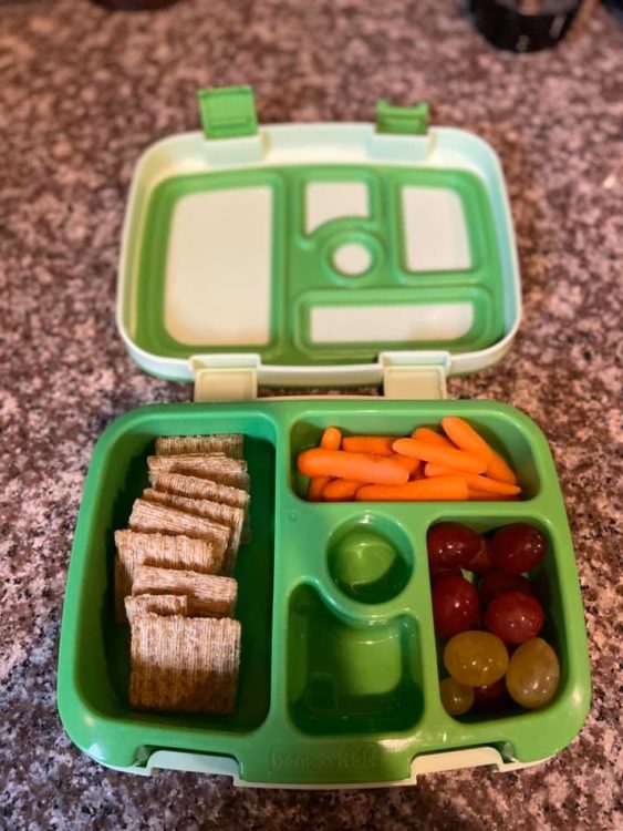 bento box with carrots, crackers and grapes