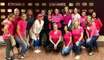 A group of women wearing pink shirts and one holding a Team Jodi sign