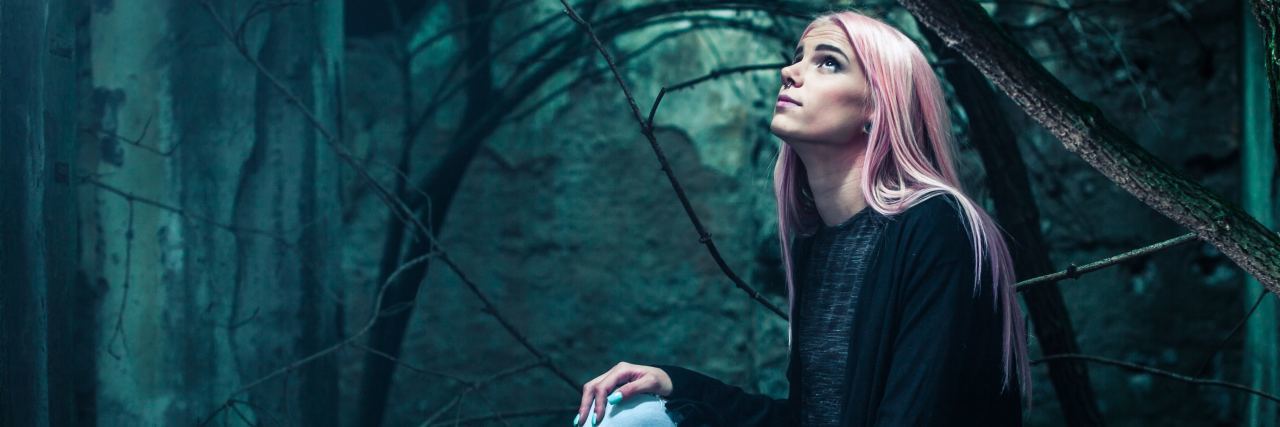 Bipolar Has Made Simple Tasks Impossible photo of woman with pink hair sitting in woods and looking up