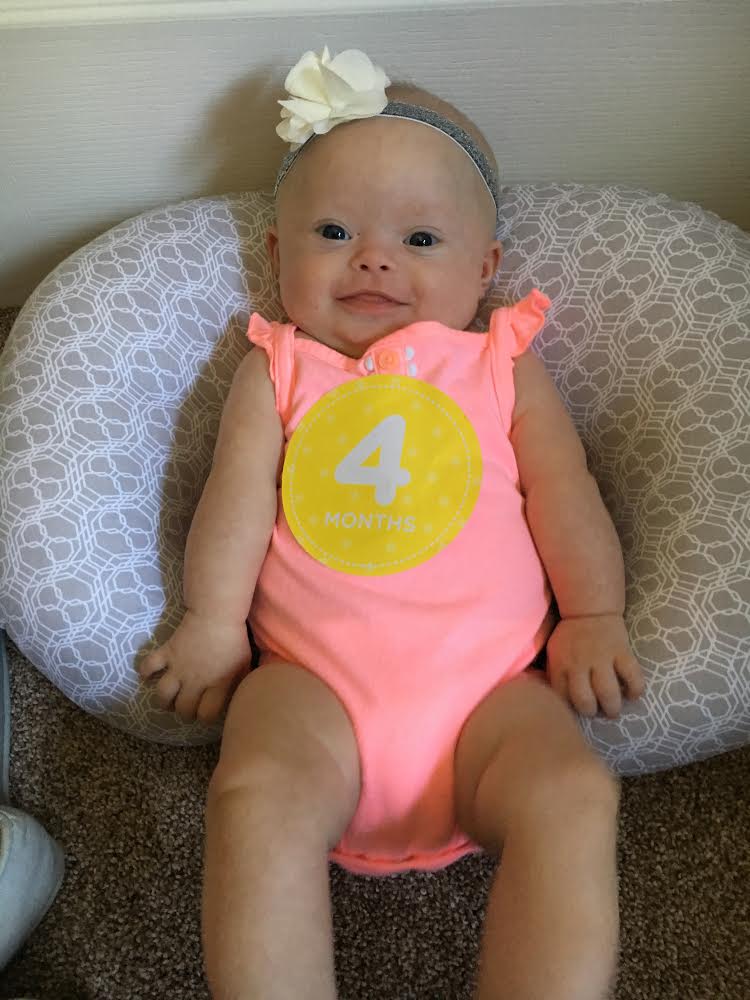 Baby Alice wearing a pink onesie.