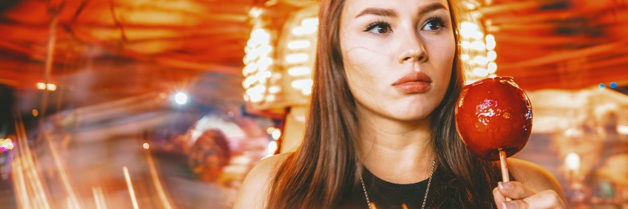 I Cant Enjoy Halloween With My Son Because of PTSD photo of woman at funfair with candy apple