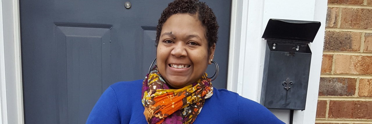 The Strong friend Who Is Chronically Ill A woman in a blue dress stands smiling facing the camera.