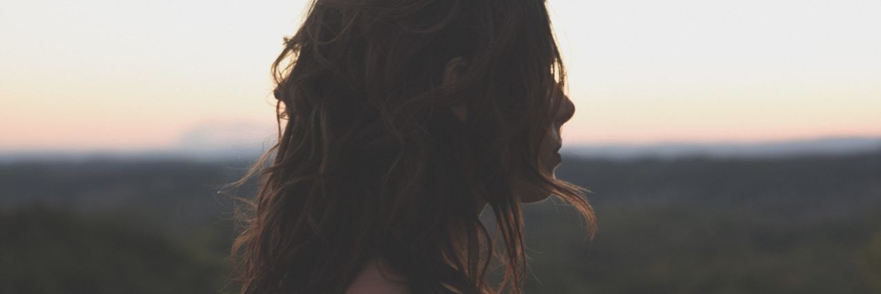 photo of woman silhouetted at sunset in profile