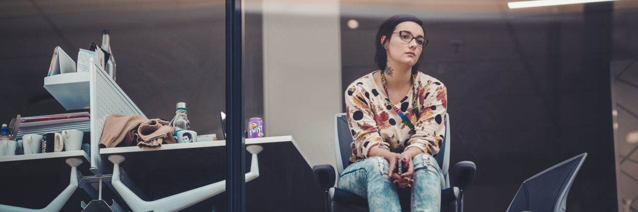 Ways to Cope With Workplace Anxiety photo of woman in office looking upset or tired