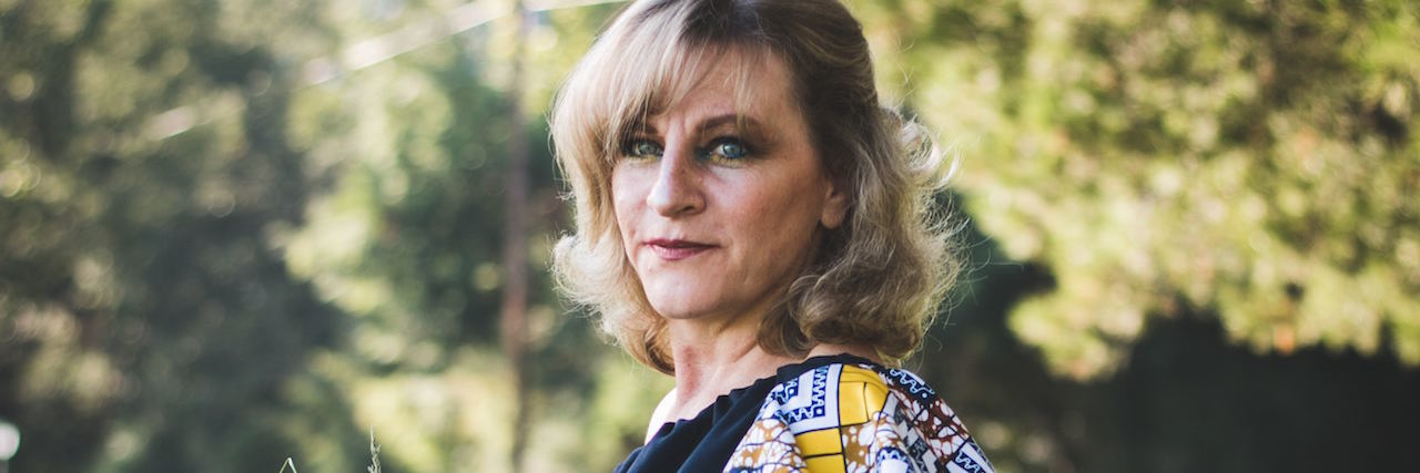 Bipolar Disorder: Feeling Like You Haven't Accomplished Enough Woman standing outside holding a sprig