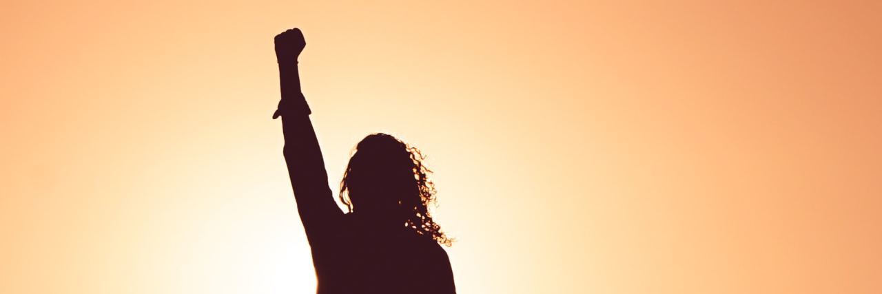Anger at How Diet Culture Affects People and Eating Disorders photo of woman silhouetted against sunset with fist raised into air