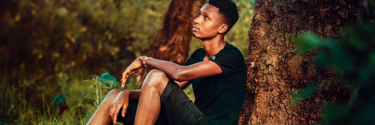How to Give Your Therapist Uncomfortable Feedback photo of teen sitting on ground with back to tree looking up wistfully